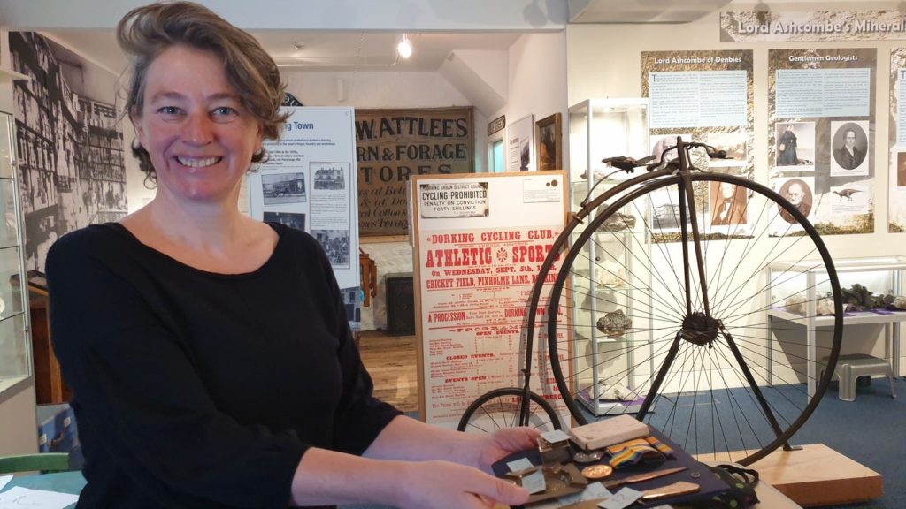 Woman holding medals in a museum