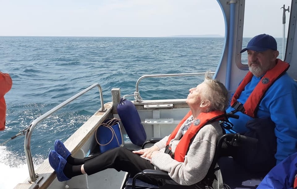 woman in a wheelchair and a man on a boat