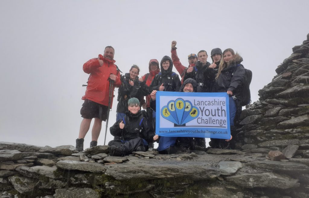 A group of people holding a banner in the rain 