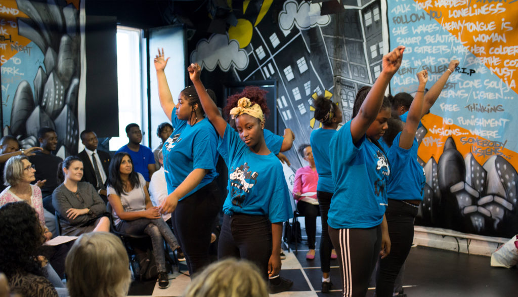 A group of children with their hands in the air from SW Youth Arts