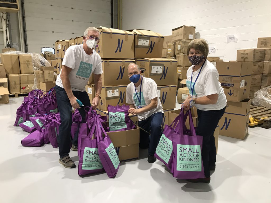 people holding small acts of kindness bags