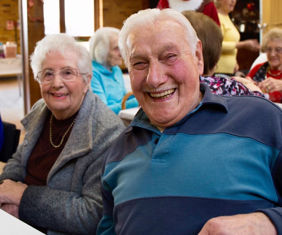 Two elderly people smiling for a photo