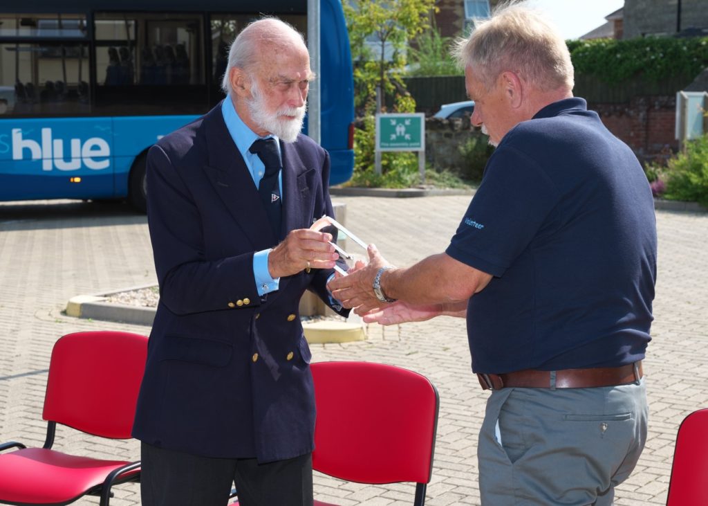 His Royal Highness Prince Michael of Kent presents QAVS crystal to volunteer of the Isle of Wight Bus Partnership