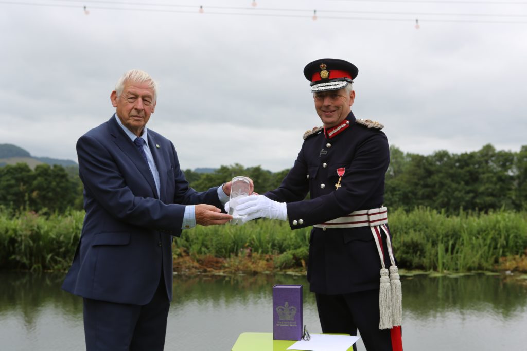 The Lord-Lieutenant hands the QAVS award crystal to a representative of The Cotswold Canals Trust